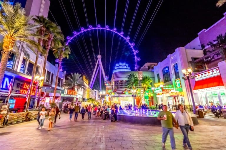 People walking down downtown las vegas - ferris wheel in the background
