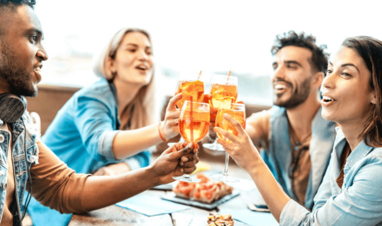 Low-Cost Vegas Getaways 2 a group of friends dining out together, clinking their glasses together in celebration